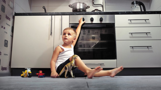 Child turning knob of stove