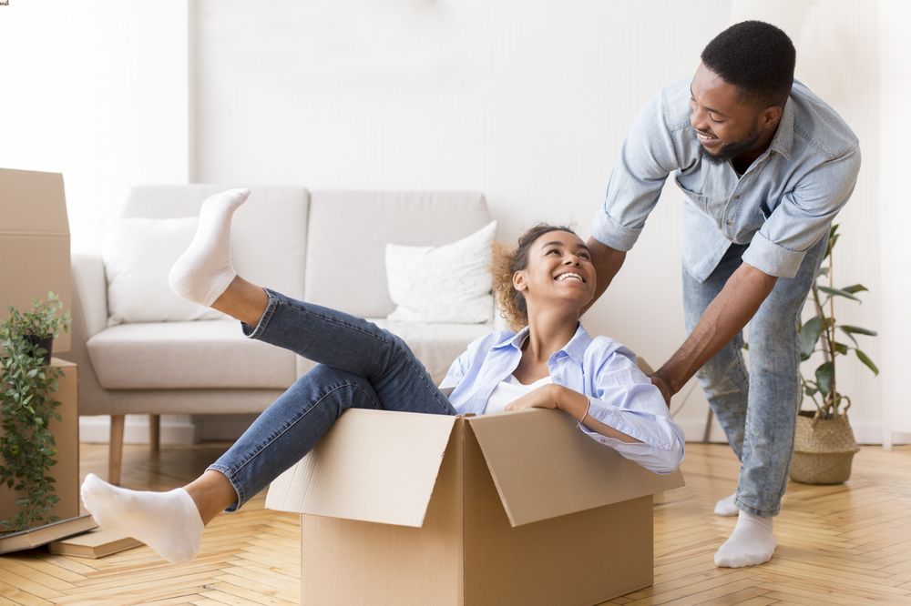 Woman in a cardboard box being pushed by a man