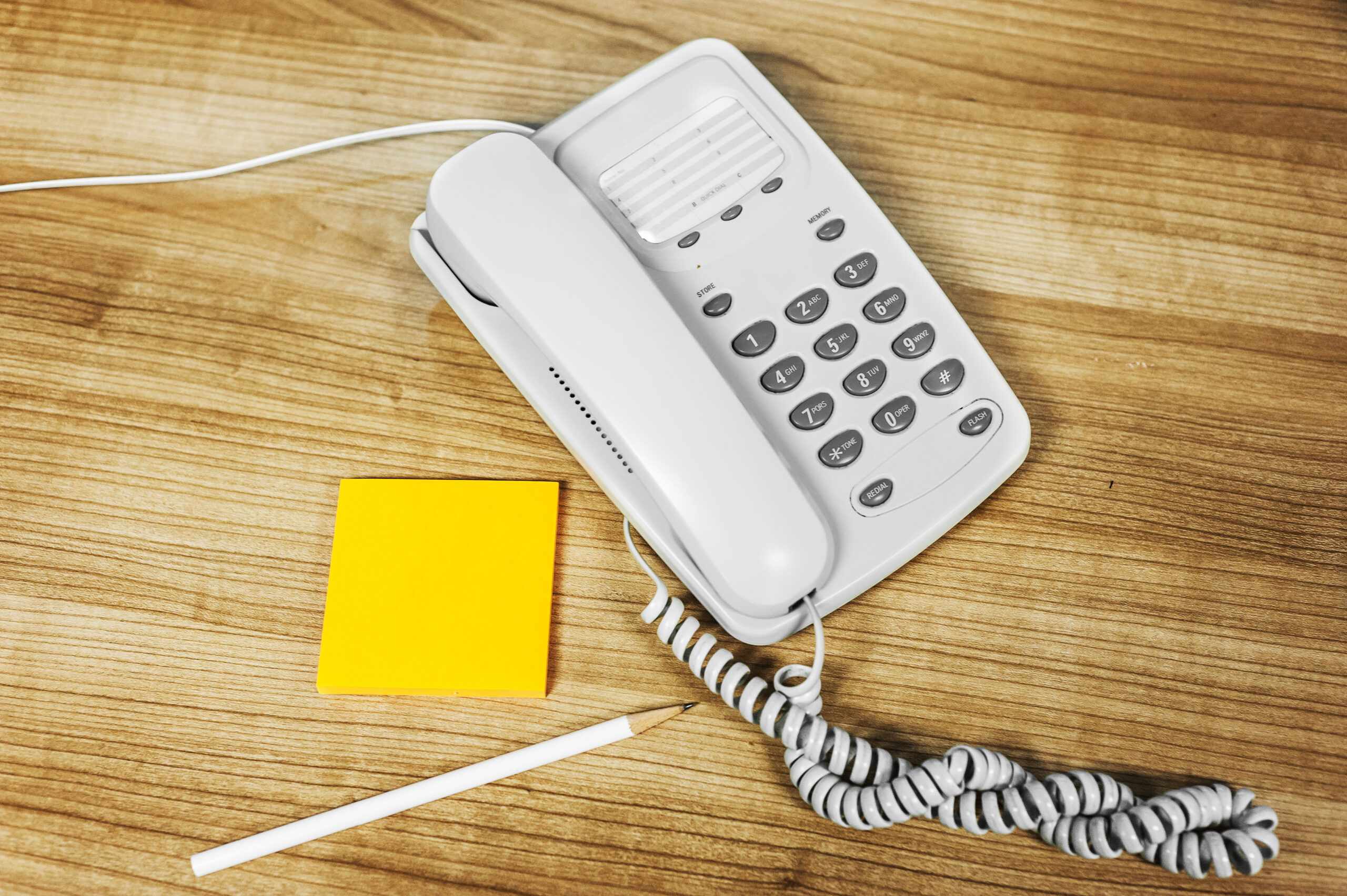 landline telephone with sticky pad and pen