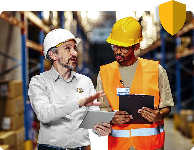 Two men in hardhats looking at a clipboard.