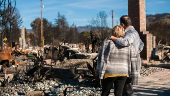 Couple looking at their burned down home